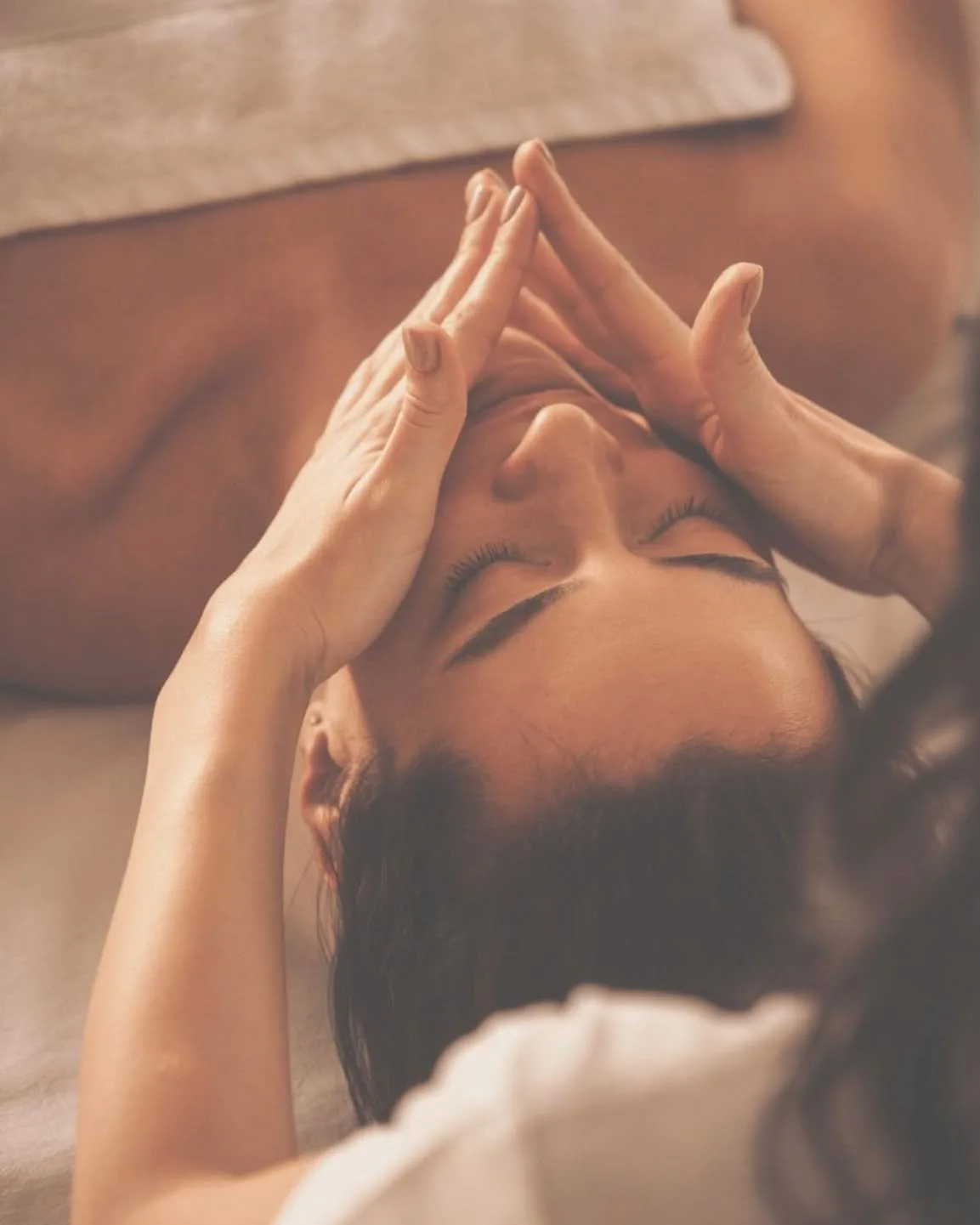 Facial pressure-point massage in warm candlelit treatment room